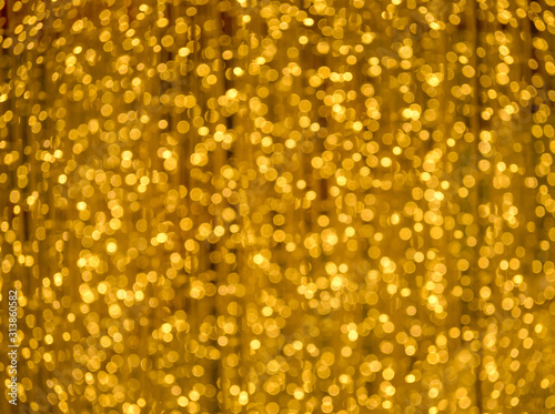Abstract blurred background of defocused blur bokeh wallpaper. Festive gold lights bokeh.