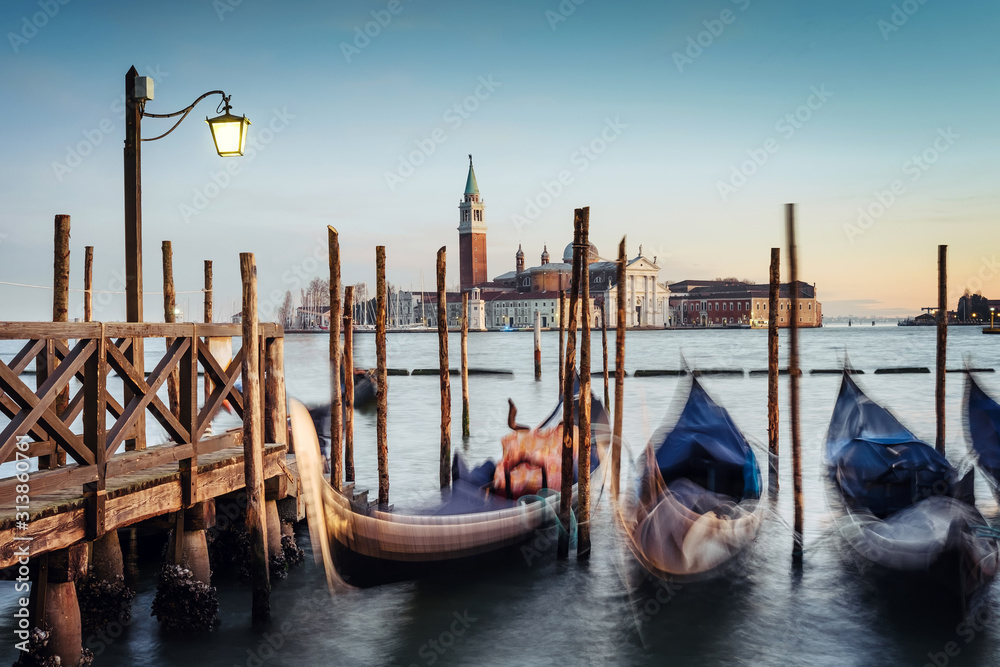 Venice, Italy - gondolas moored on the San Marco basin, in the background the church of San Giorgio Maggiore at sunset