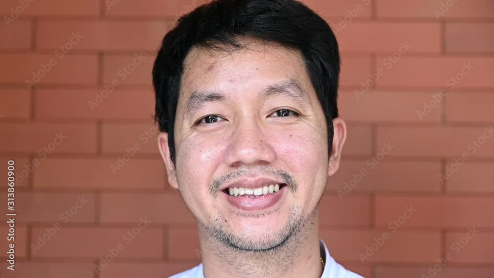 Slow motion of Portrait of happy asian man looking at camera and smiling. Hapiness portrait concept. Confident man portrait slow motion. Slow motion of Portrait of happy asian man looking at camera and smiling. Hapiness portrait concept. Confident man portrait slow motion.