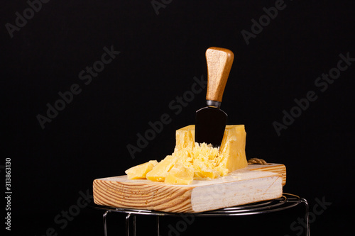 Piece of fresh tasty cheese on a black background