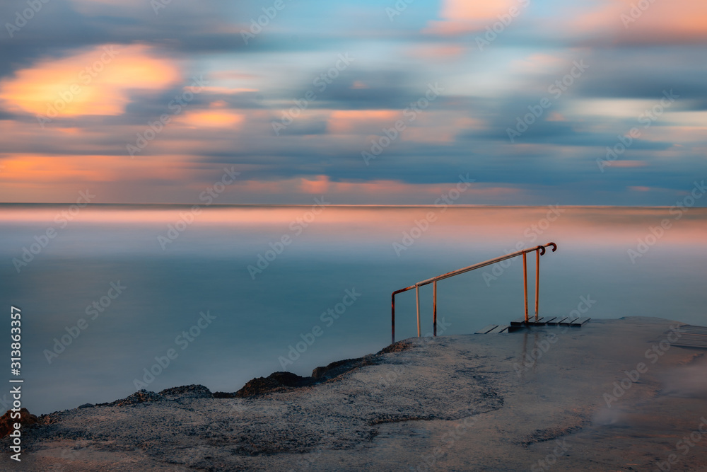 Long exposure seascape fine art photograph of pier on a sunrise in Paphos, Cyprus 