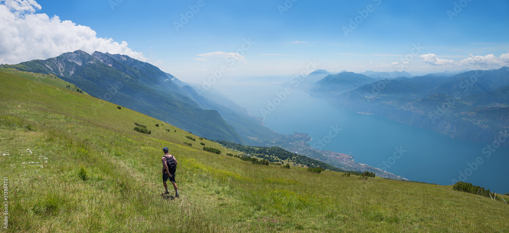 mountaineer at Monte Baldo Mountain, hiking trail in summer, view to garda lake
