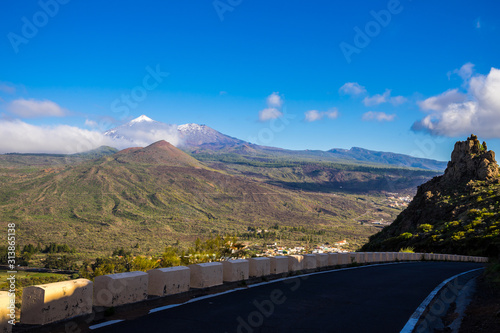Spain, Tenerife, View above colorful tree covered mountain nature landscape of teide national park, summit of volcano teide covered with white snow