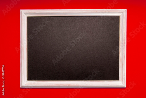 White photo frame with black middle on a red background. Space for text, copy space. © сергей назаров