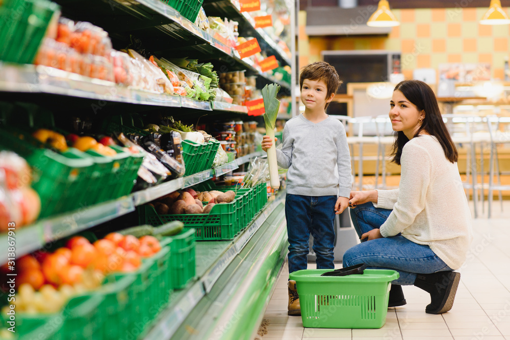 Obraz premium Mother and child shopping at farmer's market for fruits and vegetables