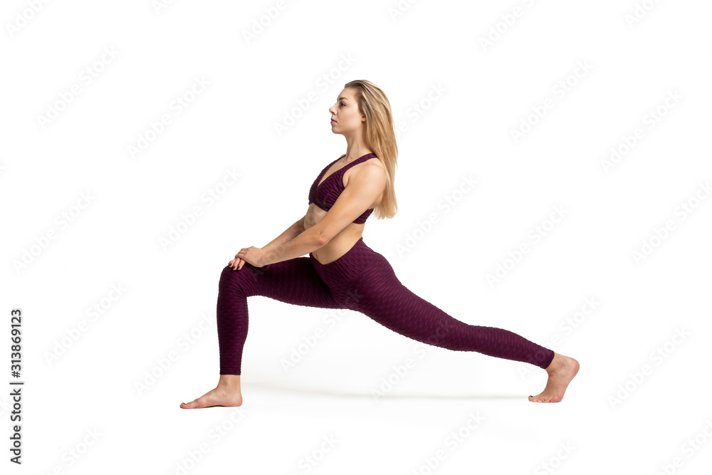 blonde girl doing gymnastic stretching dressed in sportswear with white background blonde girl doing gymnastic stretching dressed in sportswear with white background