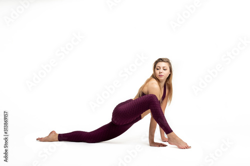blonde girl doing gymnastic stretching dressed in sportswear with white background