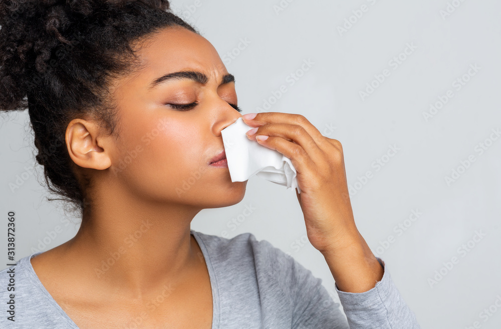 Woman touching her nose with napkin, bleeding Woman touching her nose with napkin, bleeding