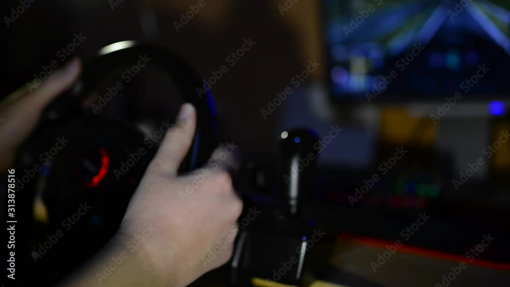 Teenage boy playing in dark on truck driving simulator in front of a computer , focus on the boys hand. Teenage boy playing in dark on truck driving simulator in front of a computer , focus on the boys hand.