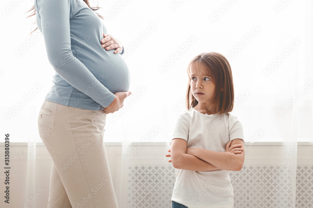 Φωτογραφία Sad little girl looking at her pregnant mother belly