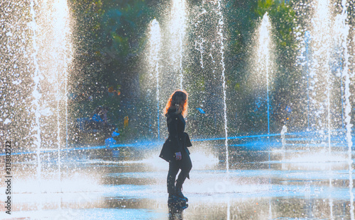 Woman walks in front of the beautiful fountain