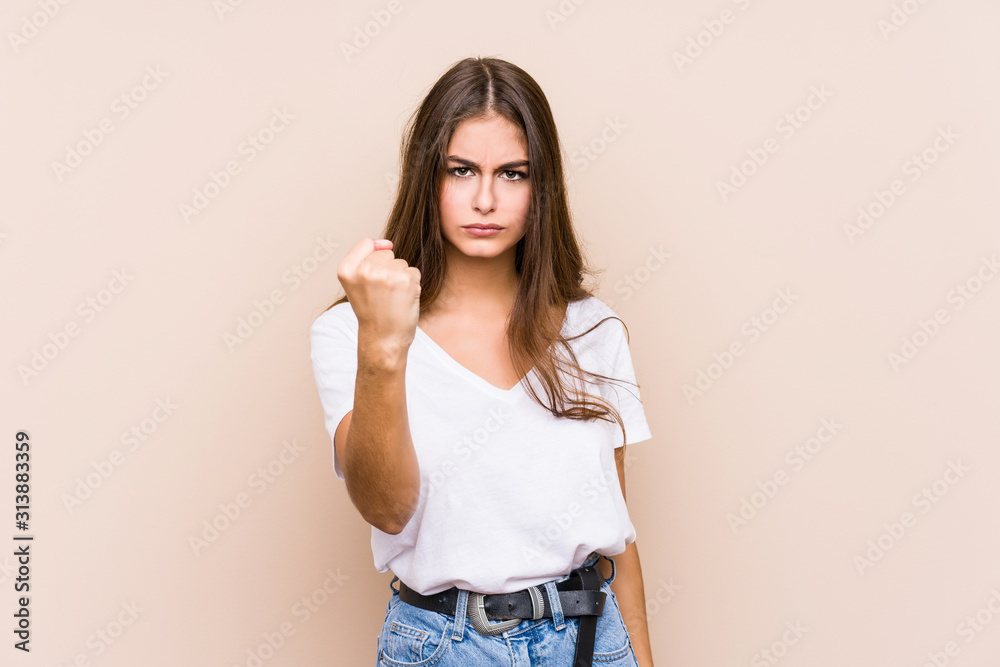 Young caucasian woman posing isolated showing fist to camera, aggressive facial expression. Young caucasian woman posing isolated showing fist to camera, aggressive facial expression.