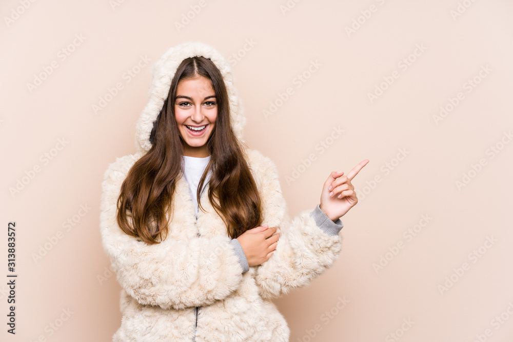 Naklejka premium Young caucasian woman posing isolated smiling cheerfully pointing with forefinger away.