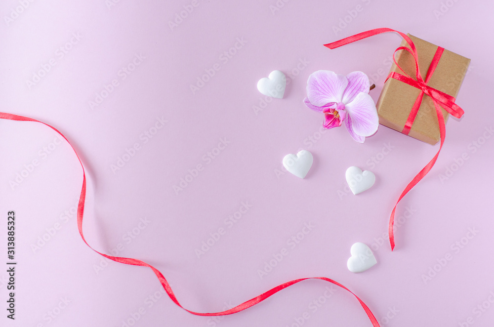 Gift box, orchid flower and white hearts on a pink background. Valentine's day and romantic concept. Flat lay. Copy space. Gift box, orchid flower and white hearts on a pink background. Valentine's day and romantic concept. Flat lay. Copy space.