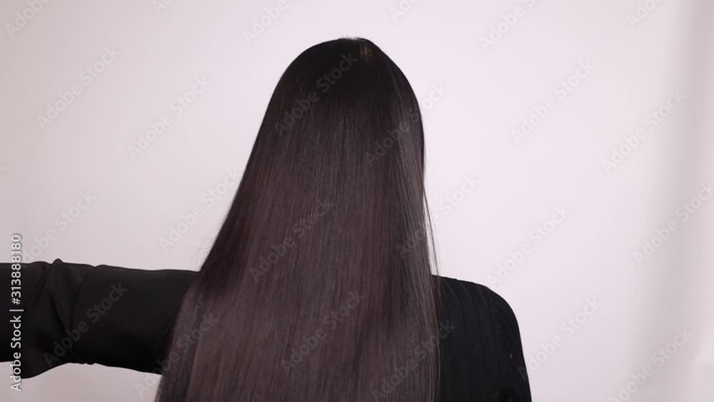 Close up of hairdressers hands drying long blond hair with blow dryer and round brush.