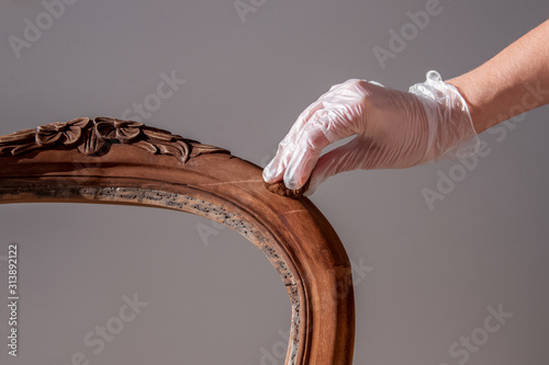 processing furniture stain with a swab made of lint-free cloth. all parts backrest, armrest, leg. Renovation of old furniture as an antique Victorian old wooden armchair.
