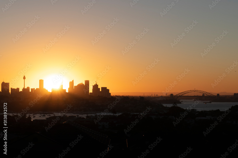 sydney skyline at sunset. sun behind the skycraper.