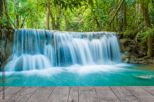 Wooden bridge with background of beautiful waterfall in rain forest © thanongsak