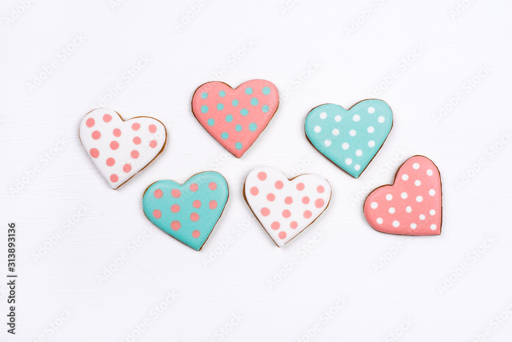 Gingerbread cookies with frosting in the shape of a heart on white background. Valentines day concept. Flat lay, top view. Gingerbread cookies with frosting in the shape of a heart on white background. Valentines day concept. Flat lay, top view.
