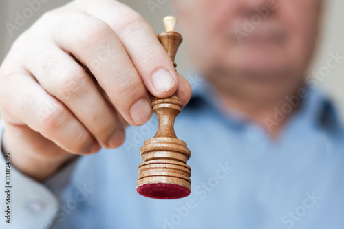 Strategy concept, hand of businessman moving wooden chess figure in play, management or leadership competition success background.