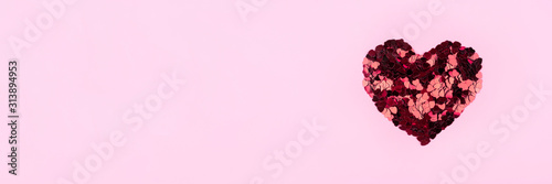 Heart of small red hearts on a pink background. Valentine's day concept. Flat lay, top view.