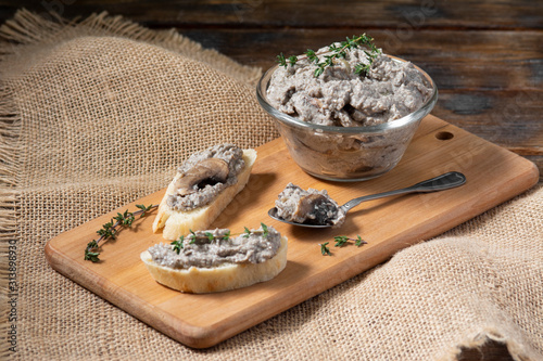 Homemade mushroom pate. Mushroom pate in a glass bowl on a brown wooden table. Vegetarian food for healthy eating
