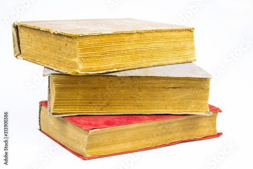 Three large old shabby books, one in red, isolated on a white background.