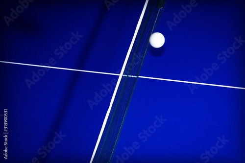 background with ball for table tennis over a table in blue with white lines
