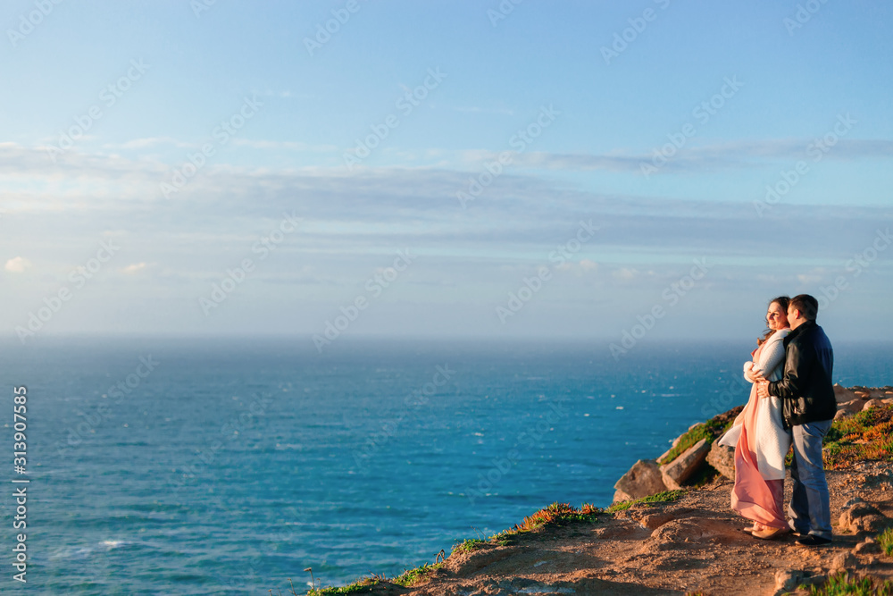 couple admiring magnificent view near ocean on sunny clear day