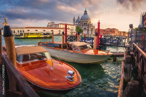 Venice, Italy - May 2, 2019: A beautiful panorama on historic attraction Basilica di Santa Maria, Venice. A view of famous Canal Grande is crowded by boats. 