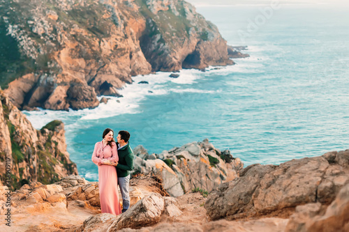 the couple in love hug on the shore of the evening ocean