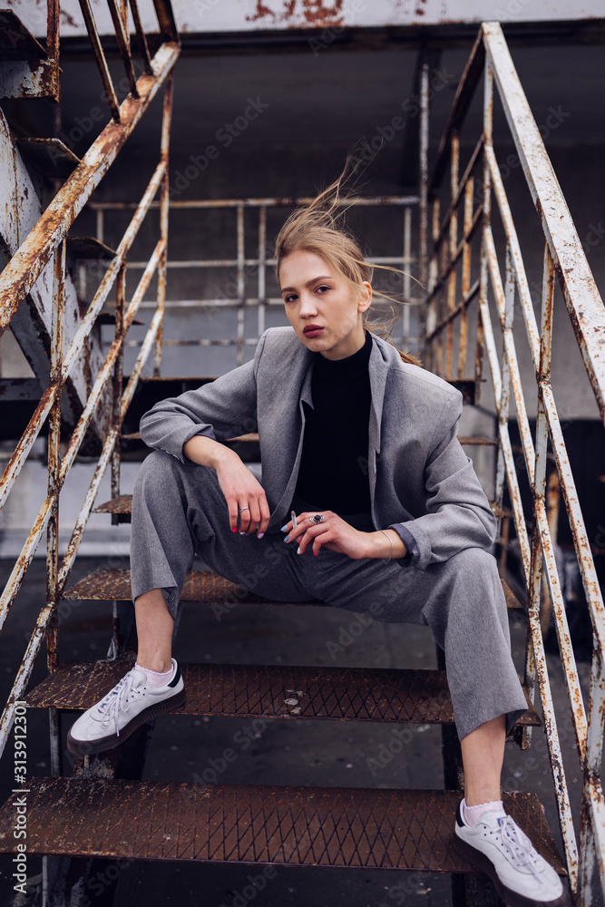 Portrait of blond woman with cigarette sitting on steps outdoors Portrait of blond woman with cigarette sitting on steps outdoors