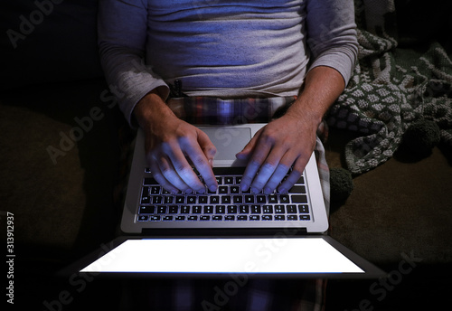 Man with laptop late in evening at home, top view