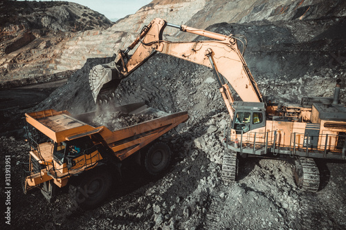 High angle view of excavator loading coal in dumper truck