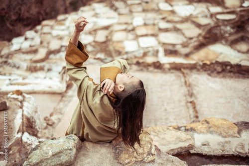 Androgynous mixed race dancer dances in salt farm on mountain side photo