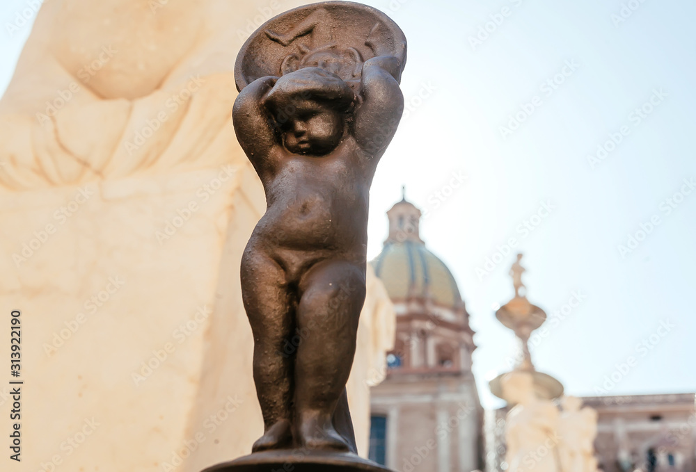 Fototapeta premium Small sculpture of ancient womanin fence of the 16th century Praetorian Fountain in historical city, Palermo.