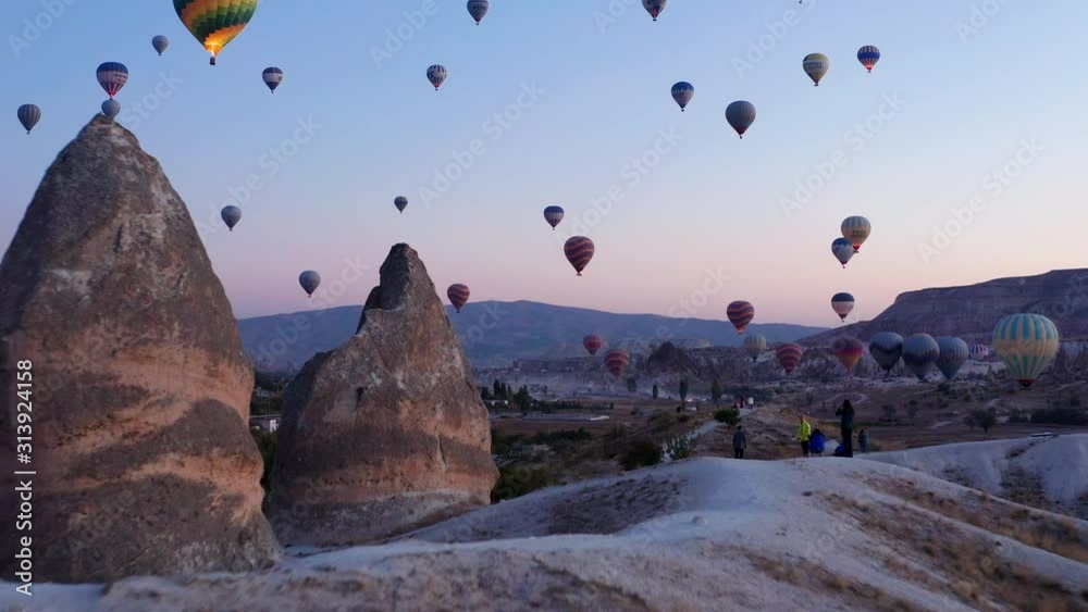 Hot air balloons fill the morning sky at Goreme, forward push over breathtaking landscape of Cappadocia