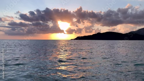 Beautiful sea sunset footage with clouds and red sun. Mountains near ocean. Summer vacation concept