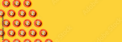Yellow web banner with orange cups of tasty coffee. Flat lay, top view, copy space. © Aleksandra Abramova