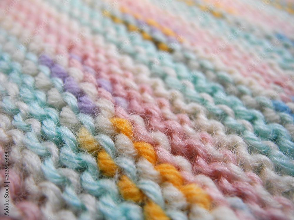 Texture of knitted fabric of motley melange wool yarn closeup Texture of knitted fabric of motley melange wool yarn closeup