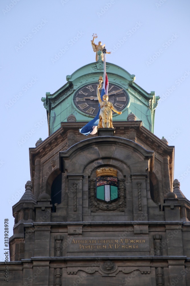Goldplated art with clock and crest of the city of Rotterdam on the city hall at the Coolsingel
