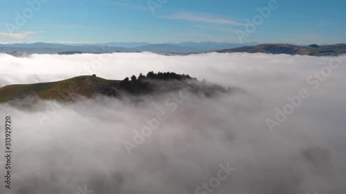 Beautiful dreamlike view of a hilltop above a sea of fog and mist. Canterbury, South Island, New Zealand.