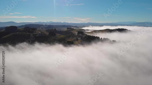 Dreamy cinematic aerial view of rolling hills in a sea of clouds, in Canterbury, South Island, New Zealand. photo