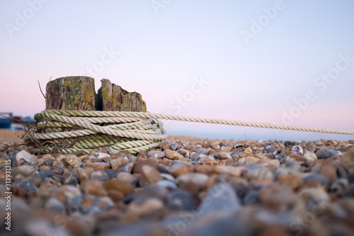 Rope tied around a post on a pebbled beach in Eastbourne, East Sussex