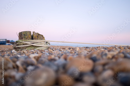 Rope tied around a post on a pebbled beach in Eastbourne, East Sussex
