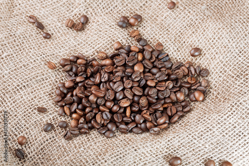 Coffee beans on sackcloth  background. Roasted coffee beans  can be used as a background