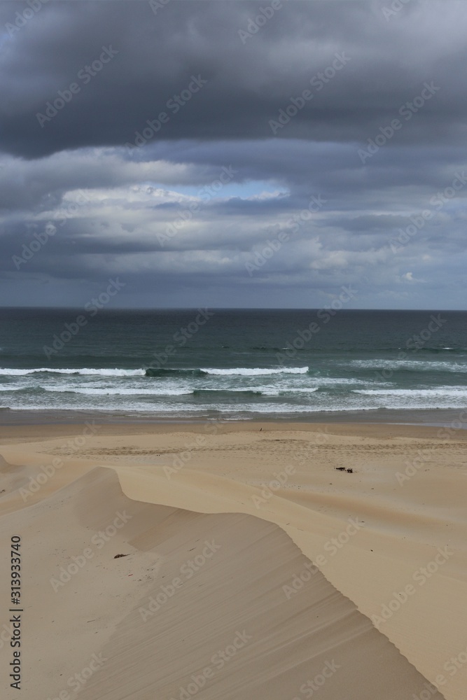Clouds and soft colours in beach view with sandy ridge Clouds and soft colours in beach view with sandy ridge