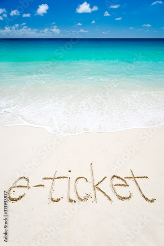 E-ticket to a vacation on a tropical beach with a handwritten message in the sand