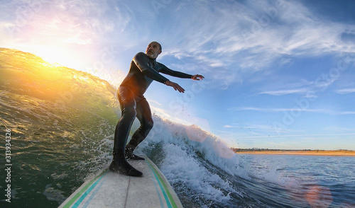 Photography Mature senior adult surfing on a big wave in the ocean