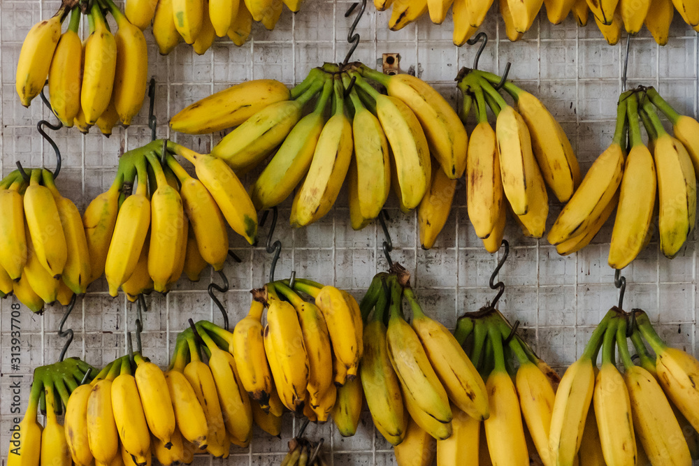 banana fruits hanging on street market for sale -